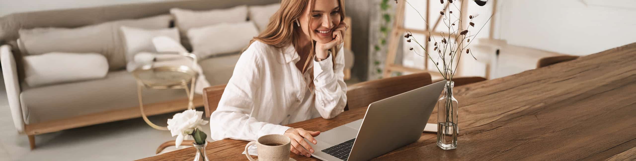 Nő a nappaliban a számítógépnél