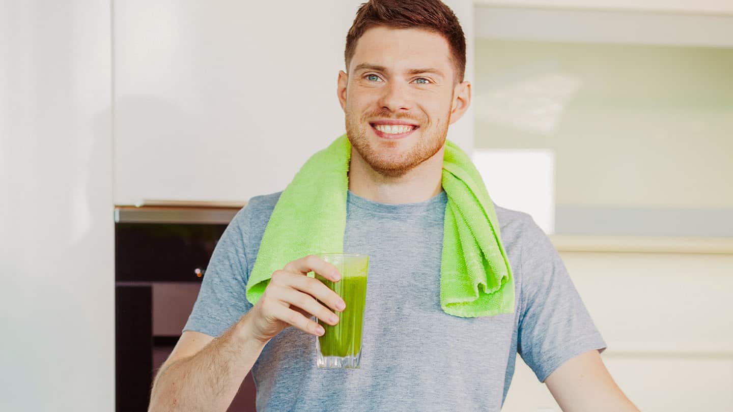 Egy férfi élvezi az egészséges zöld turmixot.