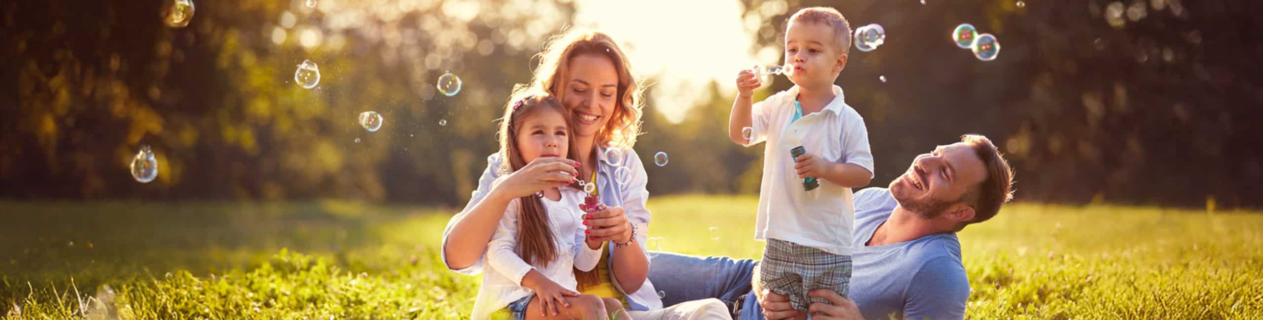 Egy gondtalan, egészséges család játszik a szabadban.