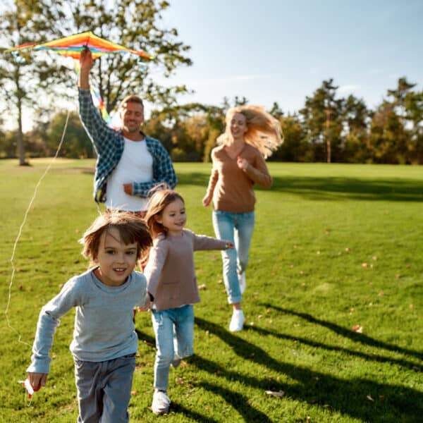 Család a szabadban, élvezve a nyaralást.