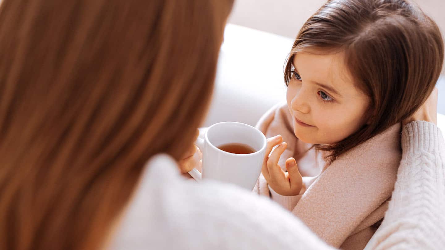 Egy anya teát kínál influenzás lányának.