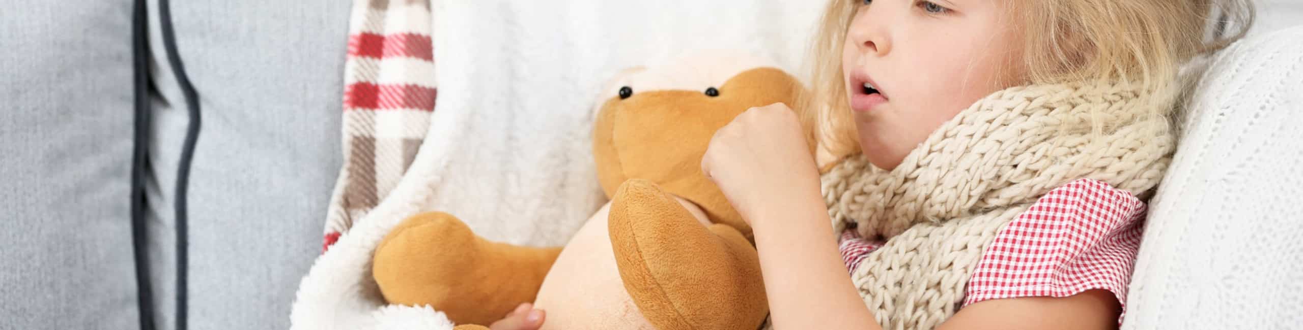 Egy beteg kislány egy plüssjátékba kapaszkodik.