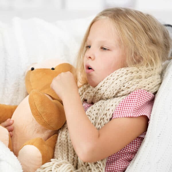 Egy beteg kislány egy plüssjátékba kapaszkodik.