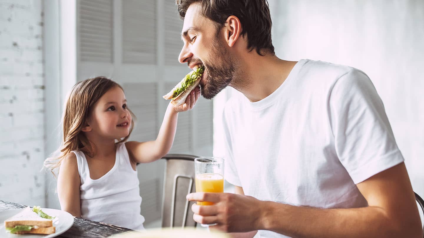 Apa és gyermeke szendvicset fogyasztanak.