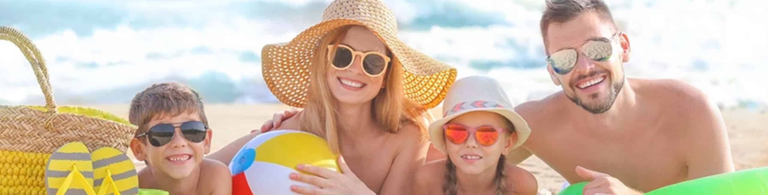 Nyár és a gyermekek betegségei; egy tengerparti család élvezi a strandot és a napsütést.