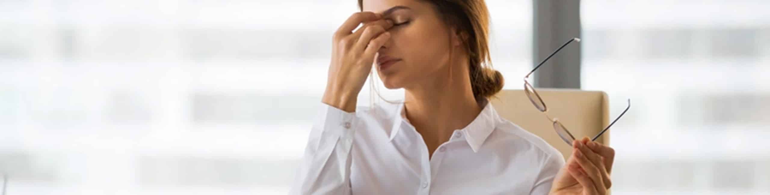 Fáradt nő az irodában az asztalnál, stressz, kimerültség.