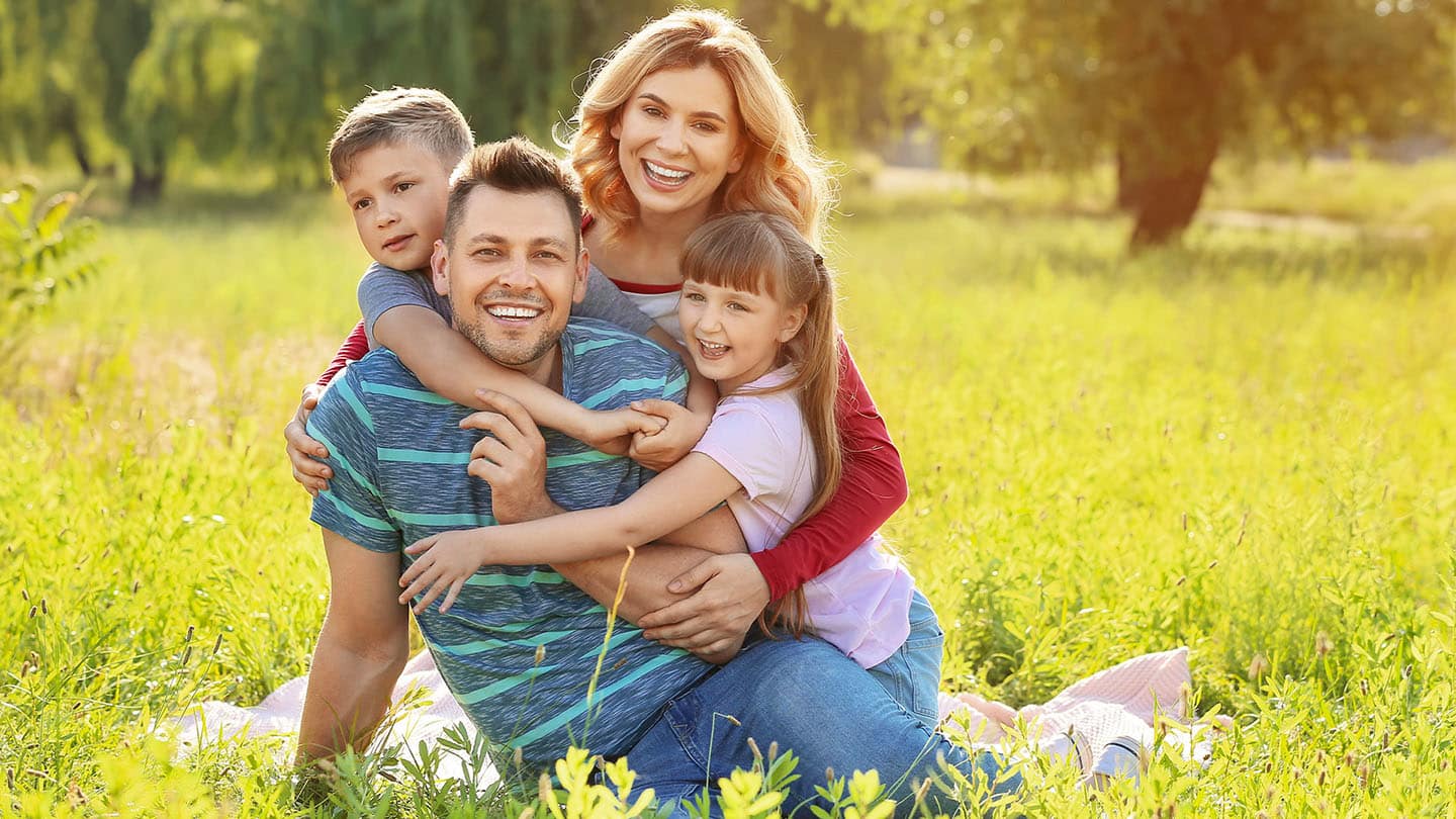 Boldog család piknikezik a természetben.