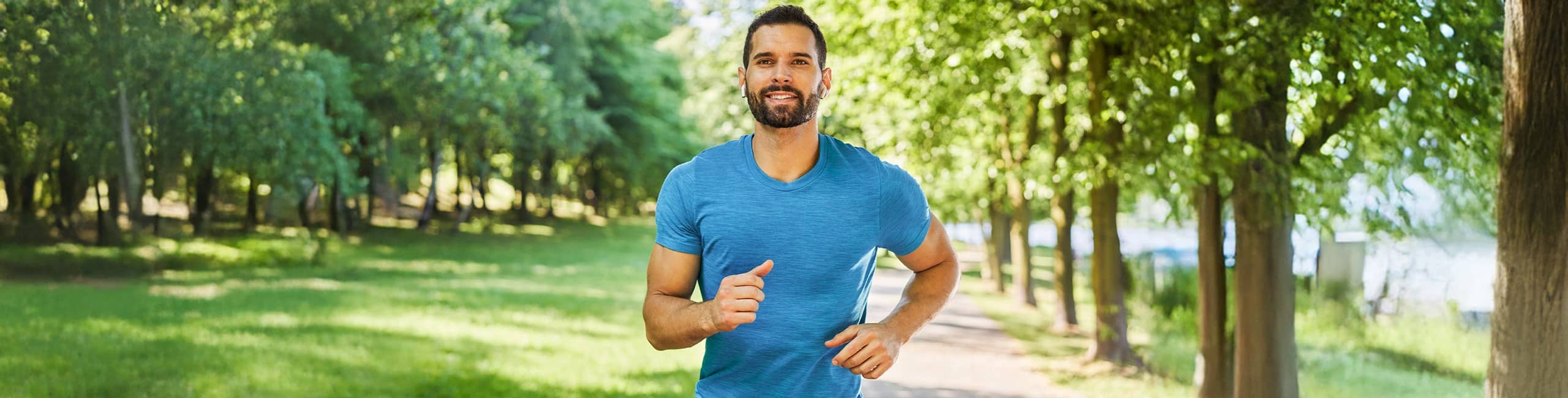 Férfi fut a parkban, fizikai aktivitás.